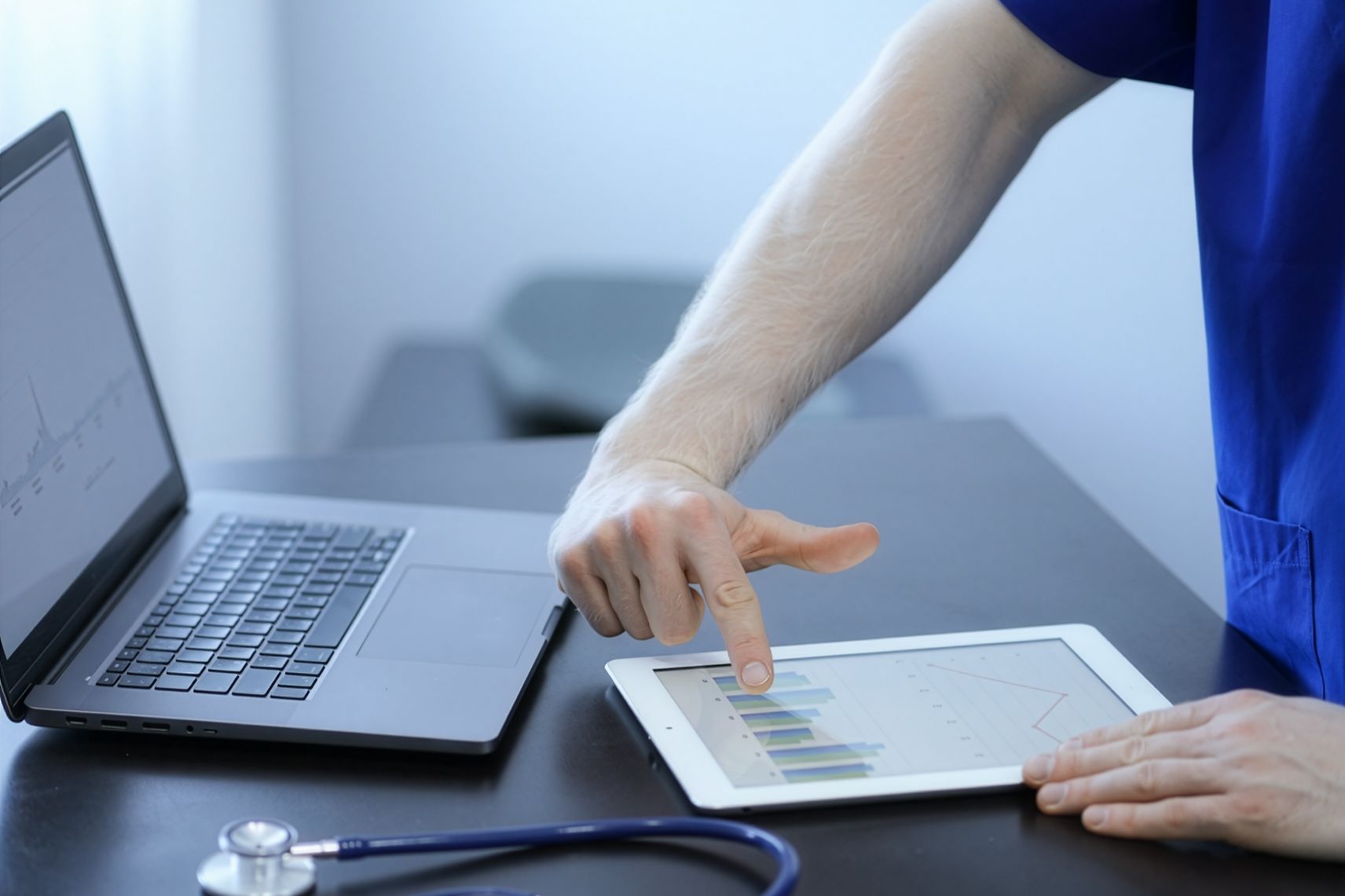 Grafici dei risultati su tablet e computer, sulla scrivania del medico
